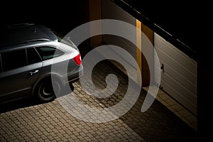 Night view of a car parked in front of the garage