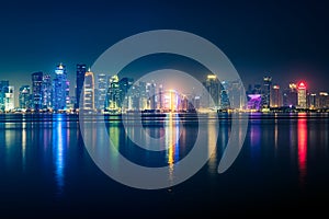 Night view on the centre of the city Doha, Qatar with many modern luxury building and skyscrapers illuminated with bright lights