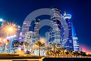 Night view on the centre of the city Doha, Qatar with many modern luxury building and skyscrapers illuminated with bright lights