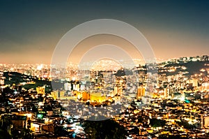 Night view cityscape of caracas during summer clear sky with view of hills with the slums, so called barrios