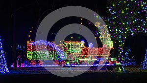 Night View Of An Elaborate Christmas Light Display Featuring A Multicolored Lit Train
