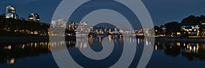 Night view of False Creek bay with marina, boats, promenade and the illuminated skyline of Vancouver downtown in Canada.