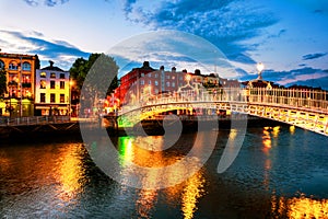 Night view of famous illuminated Ha Penny Bridge in Dublin, Ireland at sunset photo