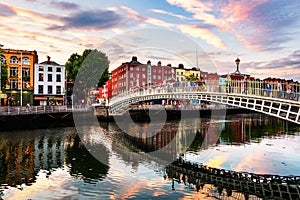 Night view of famous illuminated Ha Penny Bridge in Dublin, Ireland at sunset photo