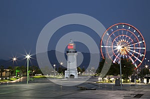 Night view of Ferris wheel and lighthouse in Batumi