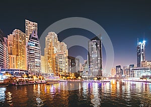 Night view of high-rise buildings of residential district in Dubai Marina And Tourist Boat, Sightseeing Boat Sailing On