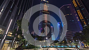 Night view hyperlapse of modern city in park with fountain and skyscrapers around. Time lapse. Hong Kong