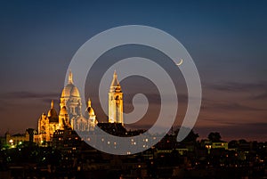 Illuminated Sacre Coeur Basilica and moon at night in Paris