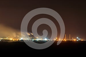 Night view of industrial district of the city and smoke pipes of factory