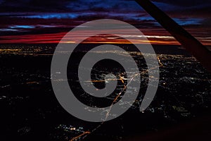 Night view from the jetplane in twilight time with the red sky and light of the city