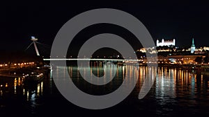 Night view of the lighted SNP bridge over Danube river and castle. Bratislava, Slovakia