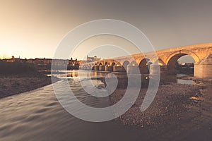 Night view of Mezquita-Catedral and Puente Romano - Mosque-Cathedral and the Roman Bridge in Cordoba, Andalusia, Spain photo