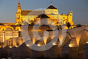 Night view of Mezquita-Catedral and Puente Romano - Mosque-Cathedral and the Roman Bridge in Cordoba, Andalusia, Spain photo