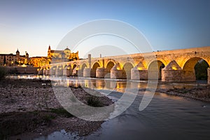 Night view of Mezquita-Catedral and Puente Romano - Mosque-Cathedral and the Roman Bridge in Cordoba, Andalusia, Spain photo