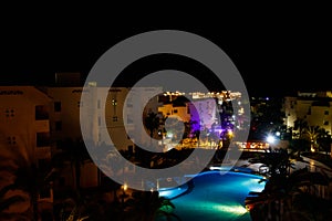 Night view of modern blue water swimming pool in tropical resort. View from above