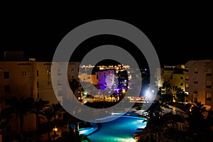 Night view of modern blue water swimming pool in tropical resort. View from above