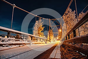 Night view at the Moon above the metal Ñable-stayed bridge in Swedish countryside, it illuminated by lights, cold winter blue