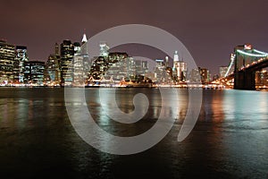 Night view of the most emblematic buildings and skyscrapers of Manhattan (New York). Brooklyn bridge. River Hudson.