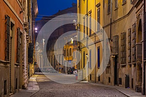 Night view of a narrow street in the old town of Piacenza, Italy