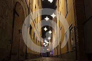 Night view of the narrowest street of Riga-Rosen Street with lanterns in the form of stars, Latvia