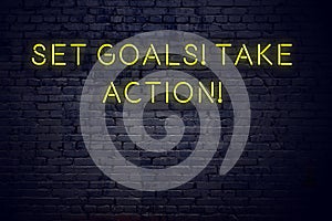 Night view of neon sign with inscription set goals take action