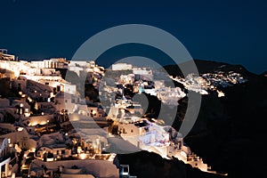 Night view of Oia town in Santorini island, Greece. Summer vacation and holiday concept, luxury travel.