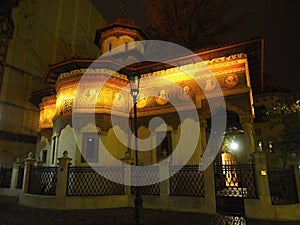 Night view of an old church of interest in the center of Bucharest with an interesting background