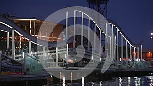 Night view of Rambla de Mar, footbridge modern design in the port of Barcelona.