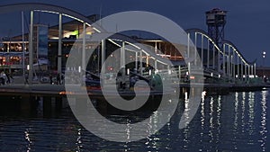 Night view of Rambla de Mar, footbridge modern design in the port of Barcelona.