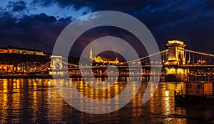 Night View Of Szechenyi Bridge. Famous Chain Bridge Of Budapest. Beautiful lighting and reflection in the Danube River.