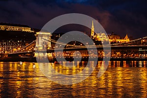 Night View Of Szechenyi Bridge. Famous Chain Bridge Of Budapest. Beautiful lighting and reflection in the Danube River.