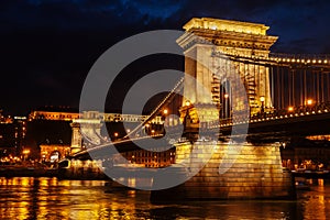 Night View Of Szechenyi Bridge. Famous Chain Bridge Of Budapest. Beautiful lighting and reflection in the Danube River.