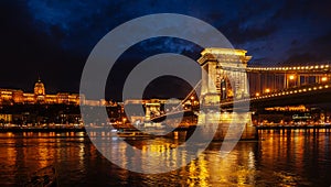 Night View Of Szechenyi Bridge. Famous Chain Bridge Of Budapest. Beautiful lighting and reflection in the Danube River.