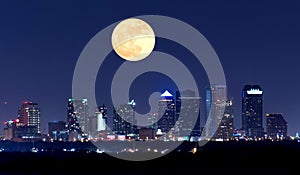 Night view of Tampa Florida skyline with huge full moon over buildings