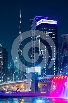 Night view to the Dubai Water Canal waterfall. Amazing rainbaw colors reflect over water.