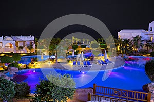 Night view to the swimming pool, building and palm trees on the beach near the red sea in Sharm El Sheikh, South Sinai, Egypt