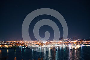 Night view toward Varna, Bulgaria. Seascape with reflection of city lights in the sea water