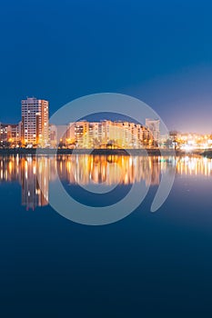 Night View Of Urban Residential Area Overlooks To City Lake Or River And Park In Evening Illumination,