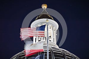 Night view of the US and the California state flag waving in the