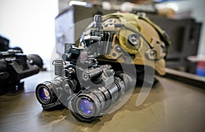 Night vision goggles on military helmet, closeup detail to blue reflective lenses