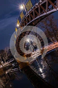 night winter bridge in the park across the river