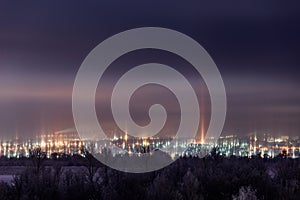 Night winter cityscape with light pillars atmospheric phenomenon photo
