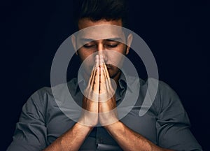 Night, worship and man with hands praying in studio to God, Jesus Christ or spiritual healing on black background. Holy