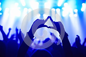 Nightclub, concert and audience with hands or sign for music, party and rave festival with spotlight and dancing. Disco