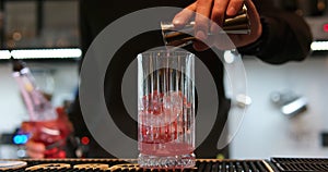 in a nightclub or pub, a professional bartender preparing a cocktail with ice a mix of alcohol. barman measure