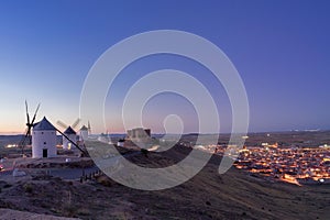 Nightfall between windmills and the medieval village of Consuegra. photo