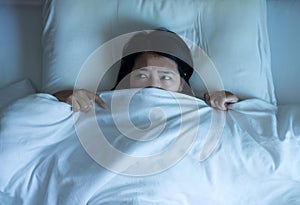 Nightmare or bad dream,Asian woman with scare and panic while lying down under the blanket in bedroom