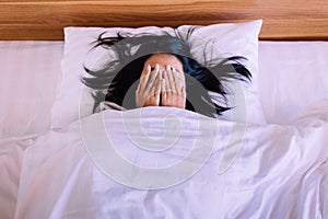 Nightmare or bad dream,Asian woman with scared and panic while lying down under the blanket in bedroom