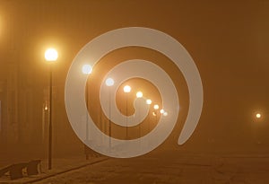 Street lamps in a foggy night city photo