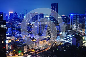 Nighttime in Bangkok city at night in Thailand. Aerial view of cityscape. Modern buildings, urban architecture and road traffic